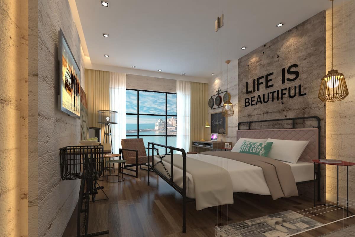 A modern bedroom with a large bed, a desk, and a view of the sea.
