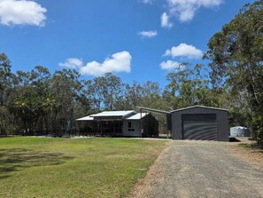A rural property with a house, a garage, and a covered outdoor area. - Boab Boat n Bush Getaway (Agnes Water)