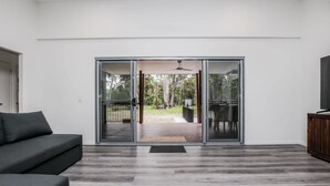Un soggiorno moderno con una porta vetrata scorrevole che dà su un patio esterno.