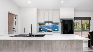 Una cucina moderna con una grande isola, forno integrato e frigorifero.