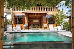 A wooden villa with a pool, outdoor seating, and a balcony. - Villa Pau Hana (Pecatu)