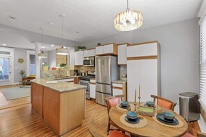 A modern kitchen with a central island, stainless steel appliances, and pendant lighting. - The Goodale House - 2 Units - 4 BR 5 Bath (Columbus)