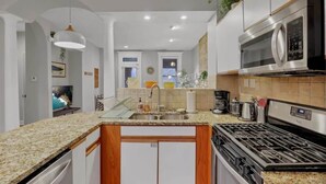 A modern kitchen with granite countertops, stainless steel appliances, and a central island.