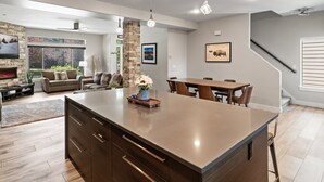 Un'ampia cucina con una grande isola, mobili in legno e luci a sospensione.