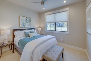 Une chambre à coucher avec un lit, des lampes de chevet, une fenêtre et un ventilateur de plafond.