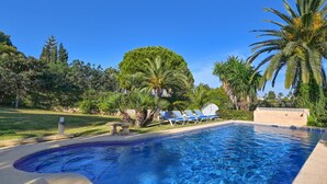 A swimming pool with blue water, surrounded by palm trees and lounge chairs. - La Desirada - Javea, Costa Blanca (Javea)