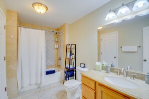 Un baño con bañera, inodoro, lavabo y cortina de ducha.