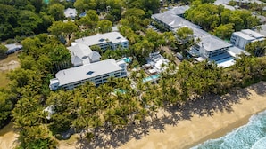 An aerial view of a resort with multiple buildings, a swimming pool, and a beach. - Belle Escapes 73 Alamanda Palm Cove (Palm Cove)