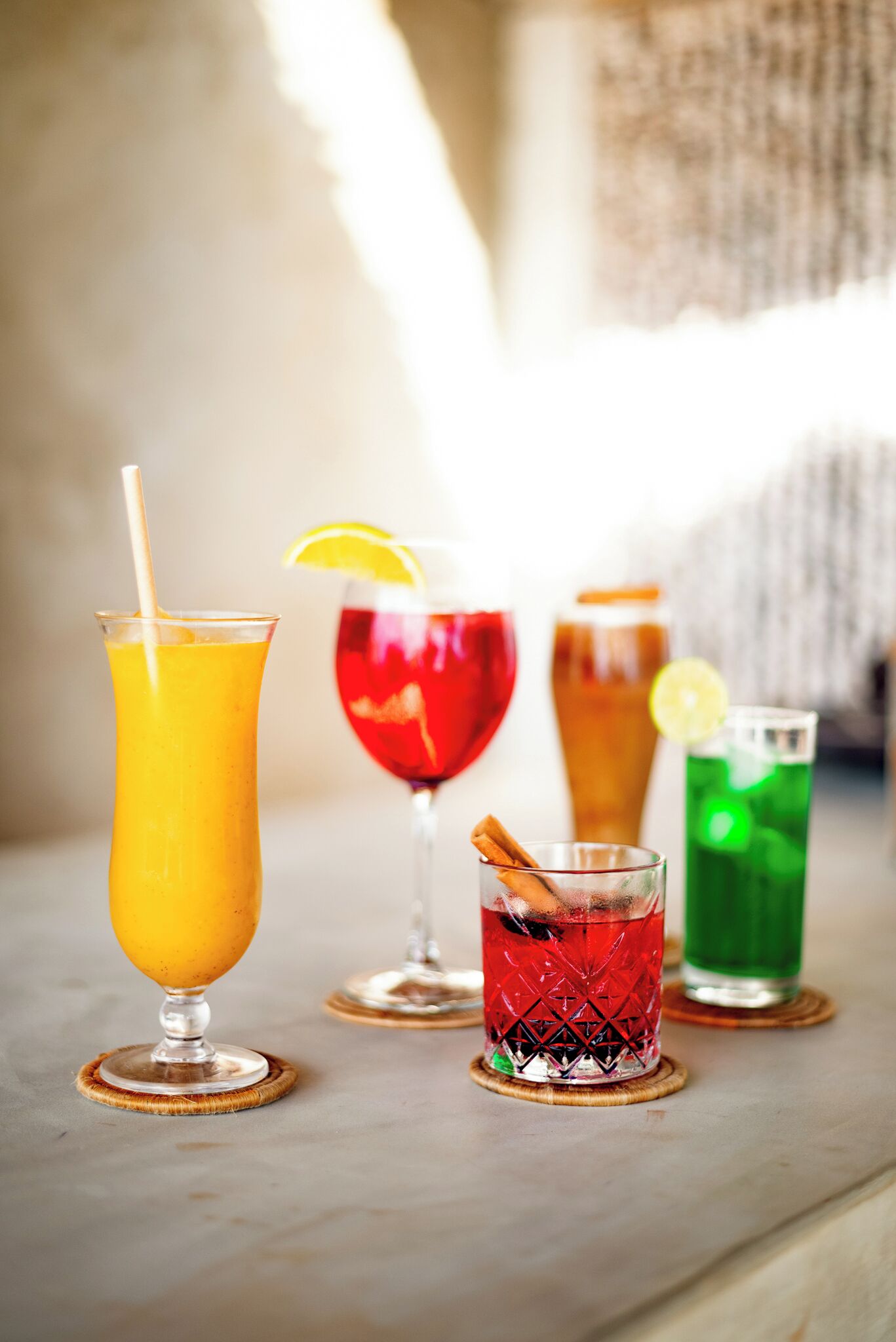 Four different drinks on coasters.