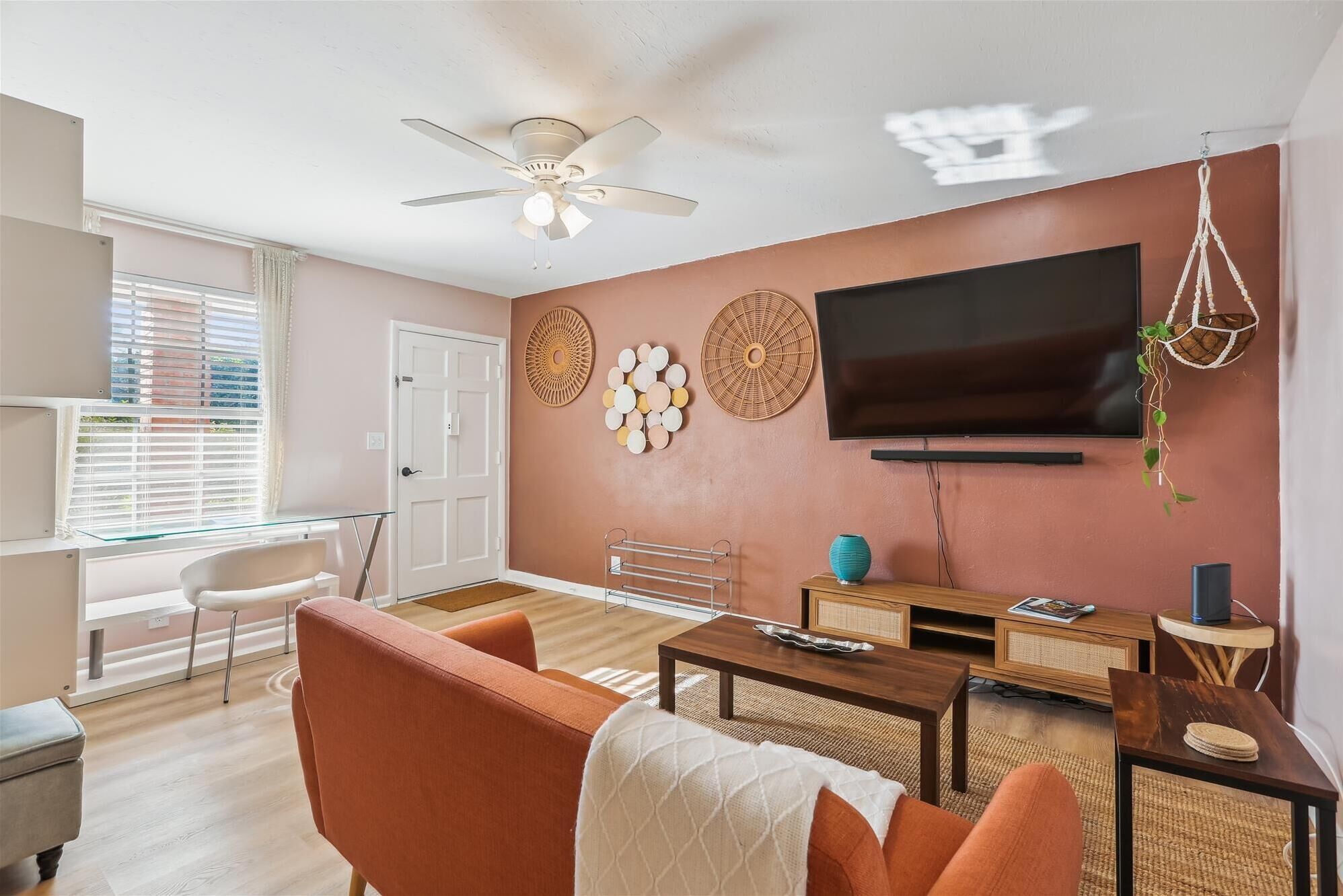 A living room with a sofa, coffee table, TV, and decorative wall art.