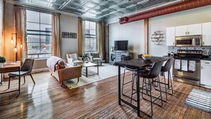 A modern apartment with a kitchen, dining area, and living room. - Modern Warehouse Loft | Walk to Rock Hall & Stadiums (Cleveland)