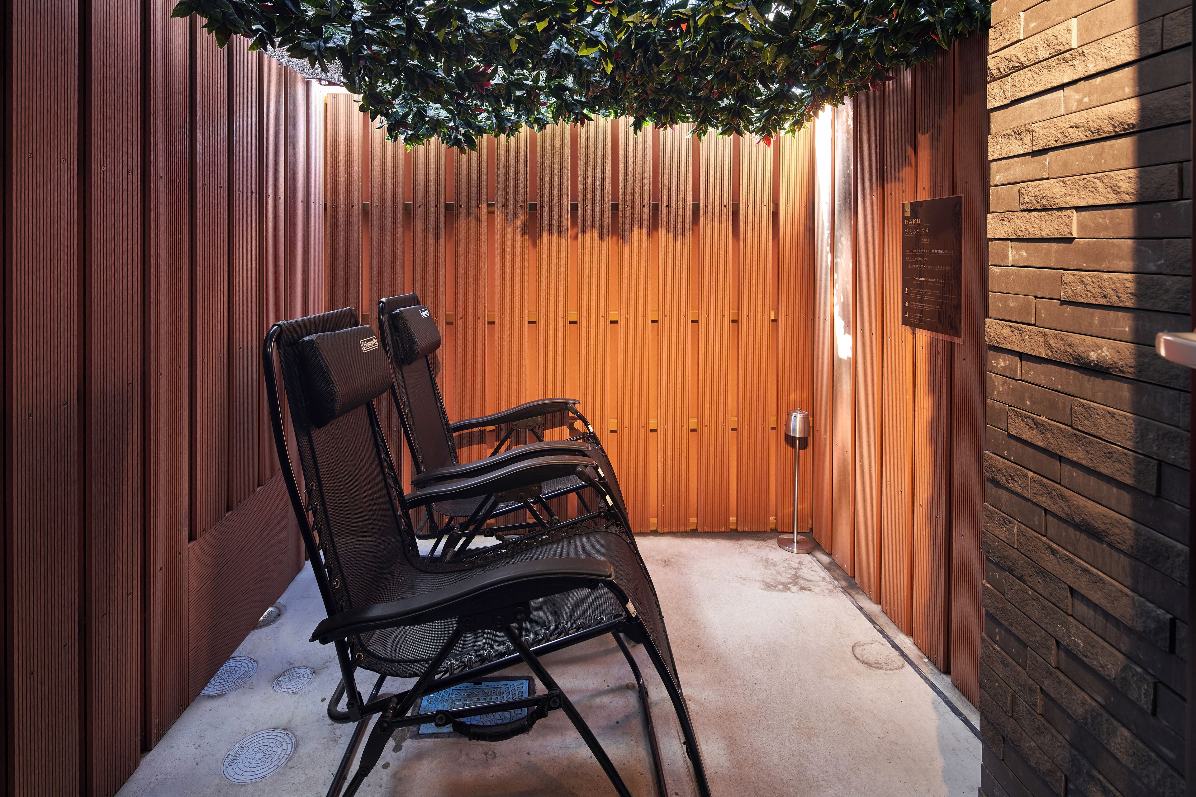 Un mur en bois avec une plaque commémorative, un banc et une porte.