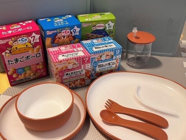 A dining setup with bowls and cutlery, and boxes of instant noodles.