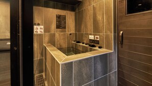 A modern bathroom with a glass-enclosed shower, tiled walls, and a wooden door. - B/C APARTMENT Asakusa Hanazono Dori Hotel with Rental Car and Sauna (Tokyo)