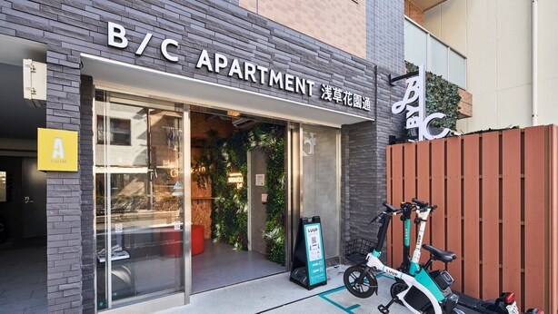 An apartment building entrance with a sign reading "B/C APARTMENT" and a signboard for "LUUP". - B/C APARTMENT Asakusa Hanazono Dori Hotel with Rental Car and Sauna (Tokyo)