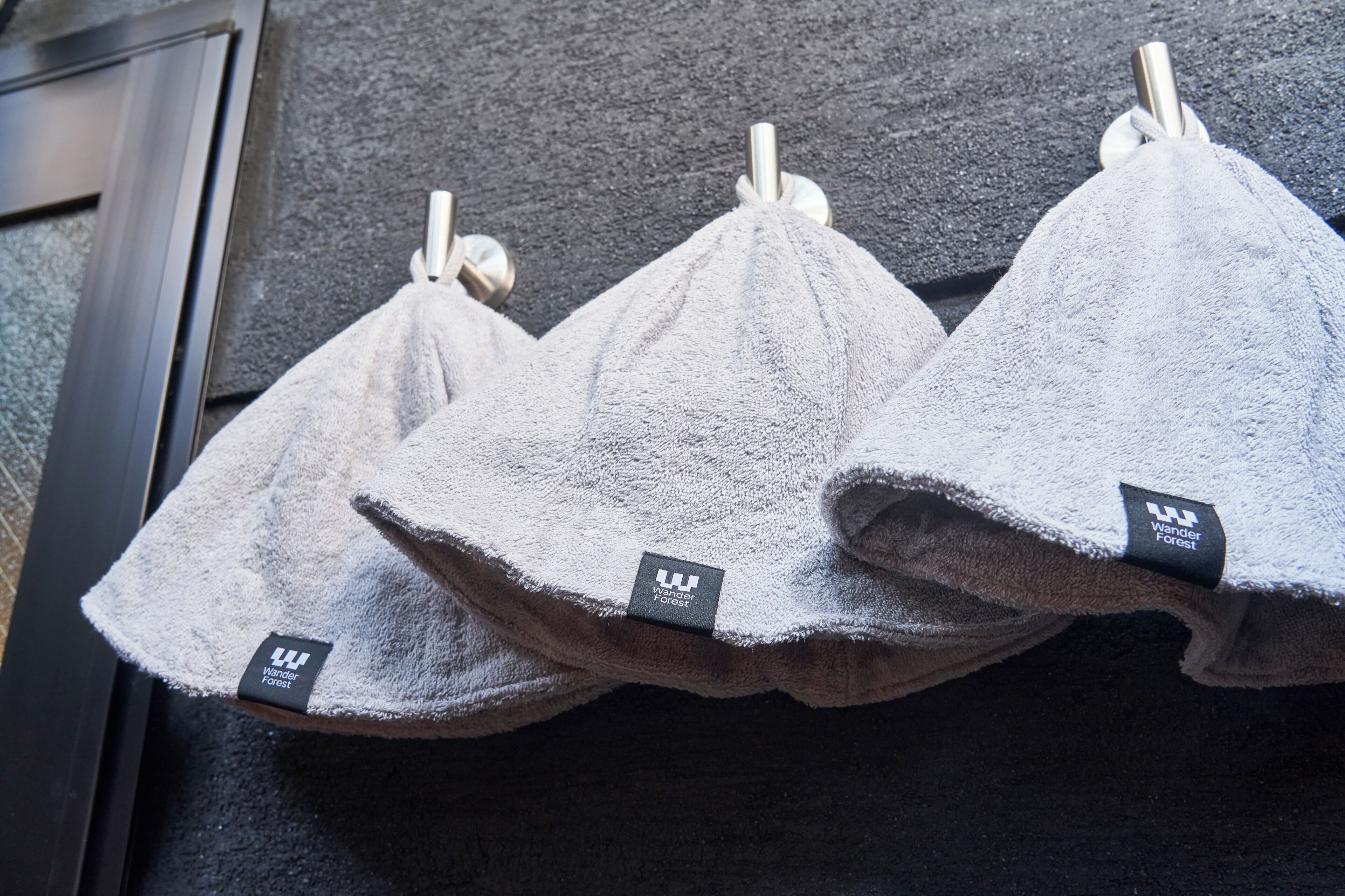Three towels hanging on a rack.