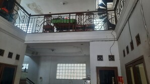 A multi-level interior with a balcony, a staircase, and a window with bars. - OYO Life 93160 Kost Jenny Karawang (Karawang)