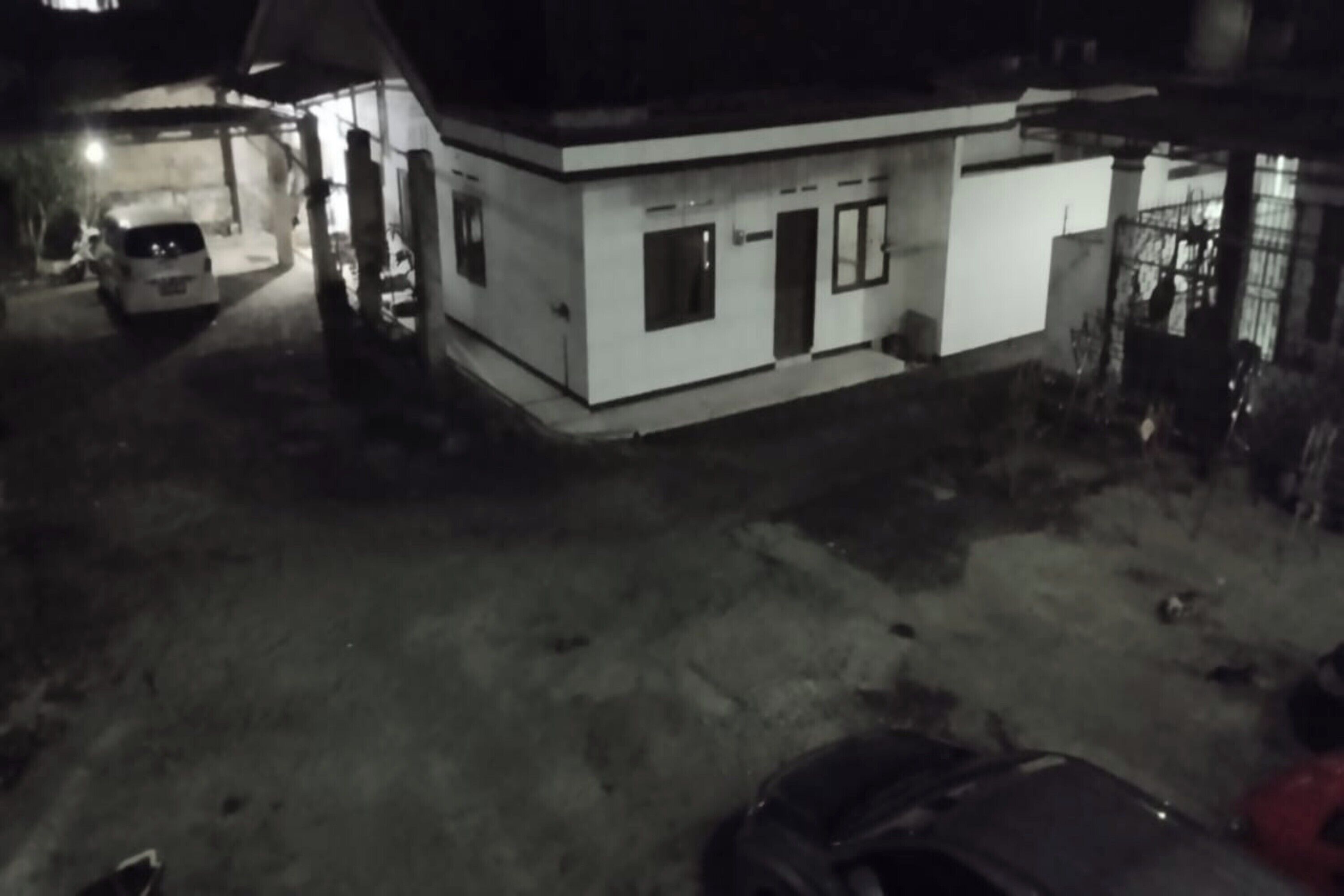 Il s’agit d’un petit bâtiment d’un seul étage, doté d’un toit plat et d’une conception simple et rectangulaire. Une voiture est garée devant le bâtiment, et une autre est visible à l’arrière-plan. L’endroit semble être un parking dépourvu d’équipements ou d’éléments particuliers.
