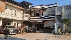 A multi-story building with a car parked in front. - OYO Life 93160 Kost Jenny Karawang (Karawang)