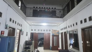 A multi-level interior with a balcony, a refrigerator, a television, and a sofa. - OYO Life 93160 Kost Jenny Karawang (Karawang)