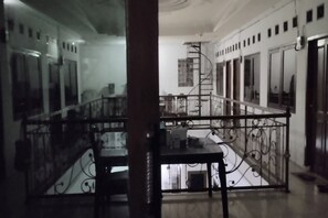 A spacious room with a balcony, a staircase, and a view of the interior. - OYO Life 93160 Kost Jenny Karawang (Karawang)