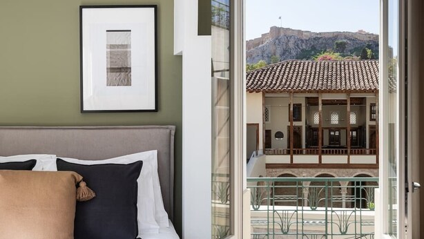 A bedroom with a bed, pillows, and a framed picture on the wall. - ATH121 - Elysian 2BR Apartment in Plaka 1 (Athina)