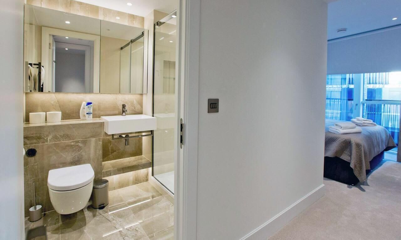 Une salle de bain moderne équipée de toilettes, d’un lavabo et d’une douche.