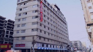 Un hôtel à plusieurs étages, reconnaissable à son grand panneau rouge.