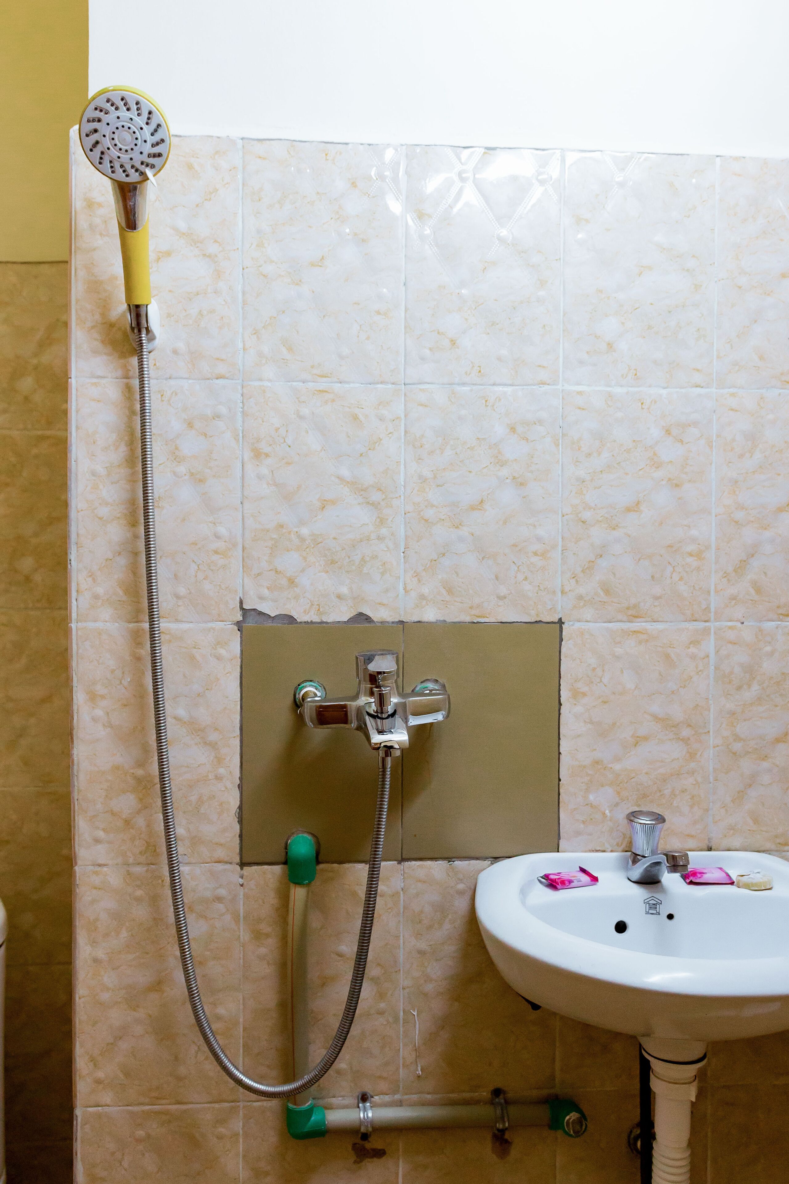 Un baño con ducha, lavabo y paredes de azulejos.