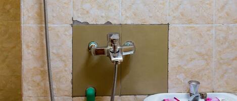 Un baño con ducha, lavabo y paredes de azulejos.