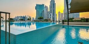 A swimming pool with a city skyline in the background.