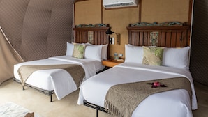 A room with two beds, a wooden headboard, an air conditioning unit, and a small table with a lamp. - La Joya Farm Resort & Spa (Aloguinsan)