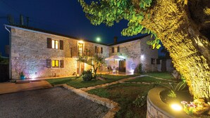 A stone building with a patio area, outdoor seating, and a well-lit garden. - 4 bedroom awesome home in Visnjan (Visnjan)