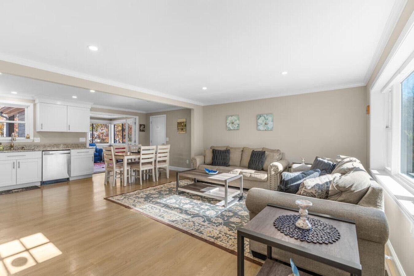 A spacious living room with a sofa, coffee table, and a dining area with chairs and a table.