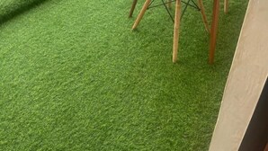 A balcony with artificial grass, two chairs, and a table. - Ruaka view (Ruaka)