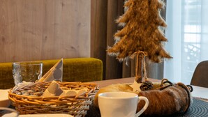 A dining table with a small Christmas tree decoration, a white cup, and various dishes.