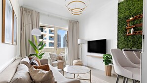 A modern living room with a sofa, chairs, a coffee table, and a TV. - Silkhaus Manchester Tower, Dubai Marina (Dubai)