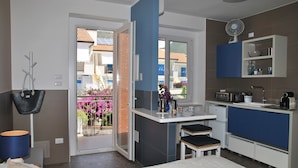A modern kitchen with a built-in oven, a microwave, and a coffee machine.