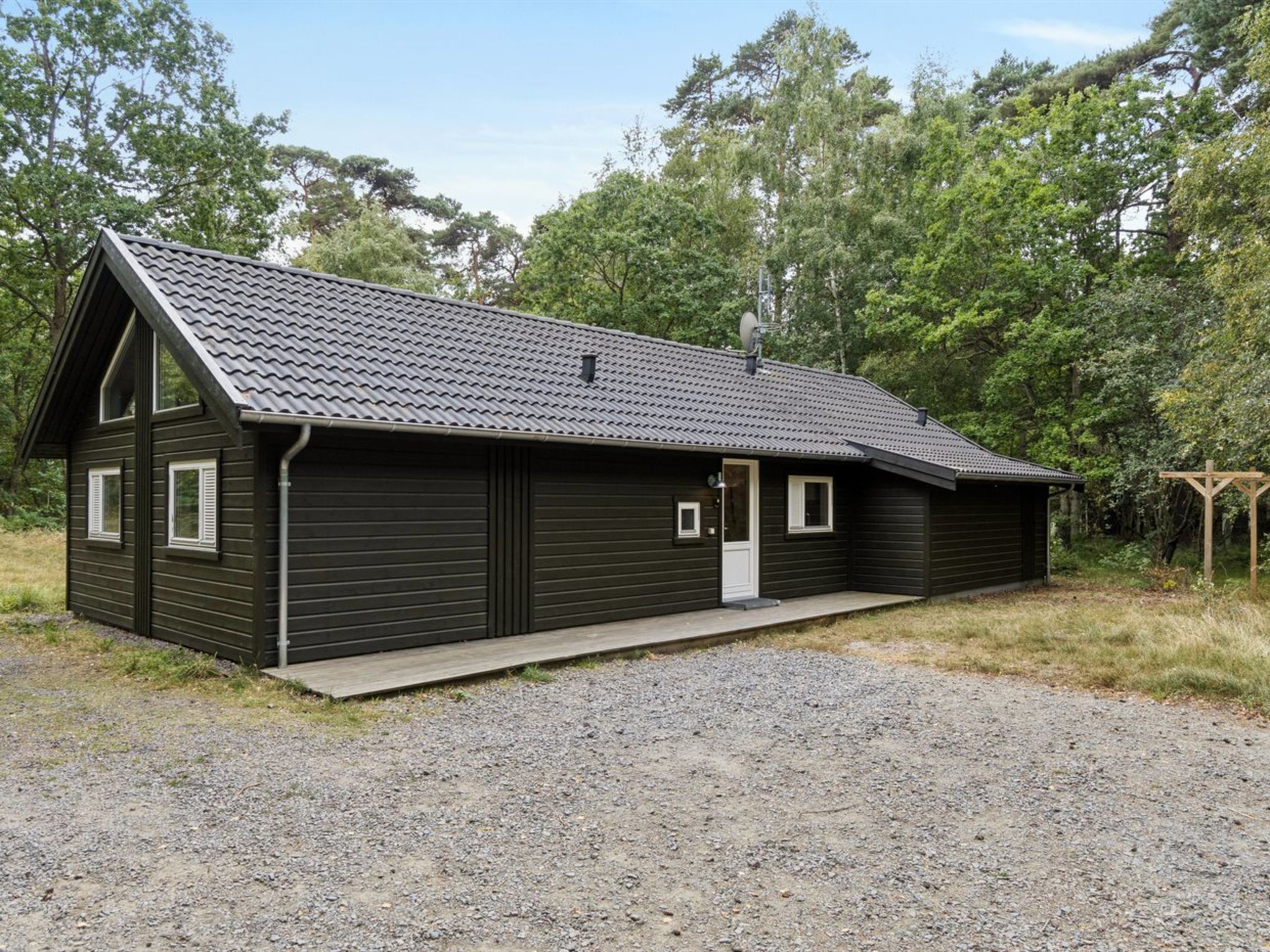 Un bâtiment d’un seul étage, doté d’un toit en pente, d’une porte de garage et d’un petit porche.