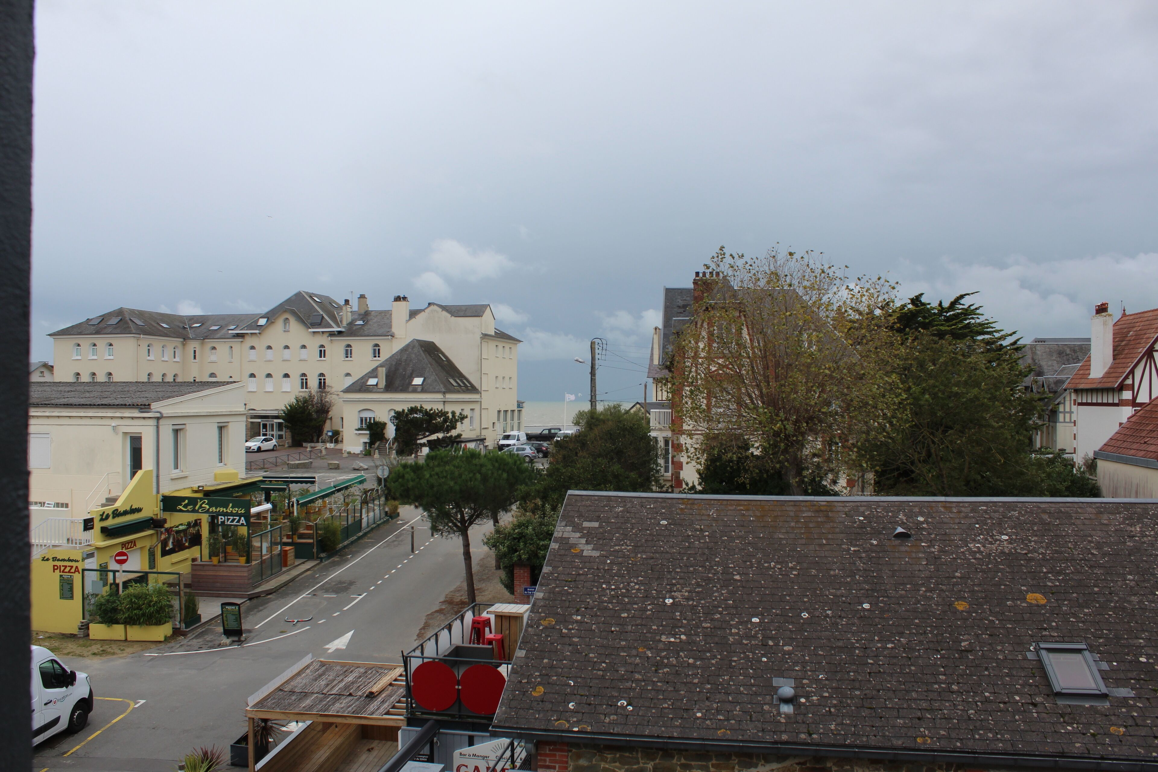 A street view with buildings, a pizza restaurant, and a clear sky.