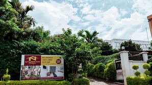 Bordje voor Nyumbani Cottages met advertenties voor bed en ontbijt, lunch en diner, koffie en gratis WiFi.