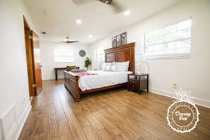 Un dormitorio con una cama de madera, una mesita de noche, un aparador y una ventana con persianas.