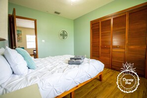 A bedroom with a bed, a wooden wardrobe, and a wall decoration. - Winter Park Charmer - Heated Pool Home - Close to everything (Winter Park)