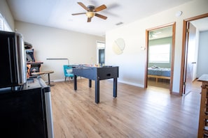 A spacious room with a foosball table, a ceiling fan, and a bed in the background. - Winter Park Charmer - Heated Pool Home - Close to everything (Winter Park)