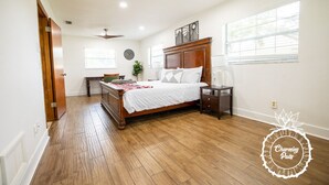 A bedroom with a wooden bed, a nightstand, a dresser, and a window with blinds. - Winter Park Charmer - Heated Pool Home - Close to everything (Winter Park)