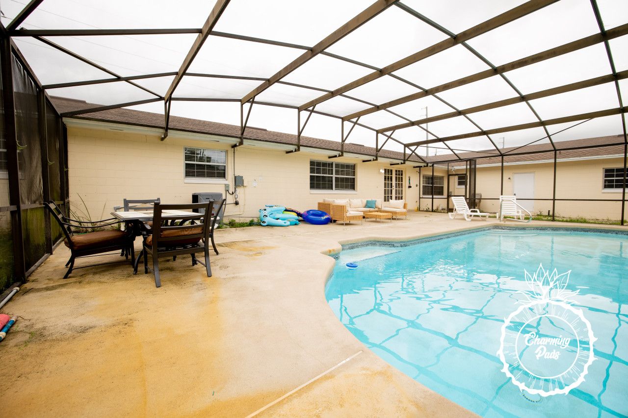 Piscina interna com um terraço coberto, incluindo uma mesa e cadeiras, e um espaço de descanso à beira da piscina.