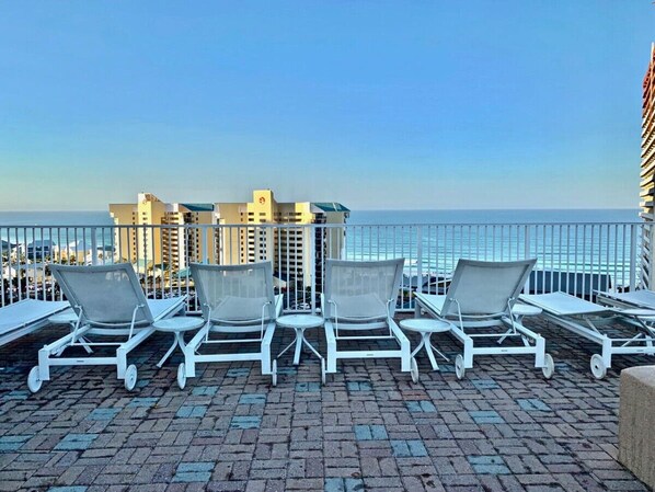 Enjoy breathtaking ocean views from this rooftop terrace, featuring comfortable lounge chairs and tables.