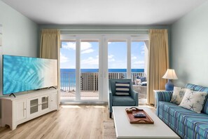 Relax in this stylish room with a large flat-screen TV, comfortable seating area, and sliding glass door leading to a balcony with ocean views.