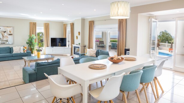 Un salon moderne comprenant un coin repas, un téléviseur à écran plat et une vue sur l’extérieur.
