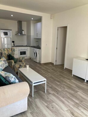 Eine moderne Wohnung mit Wohnzimmer, Küche und einer kleinen Essecke.